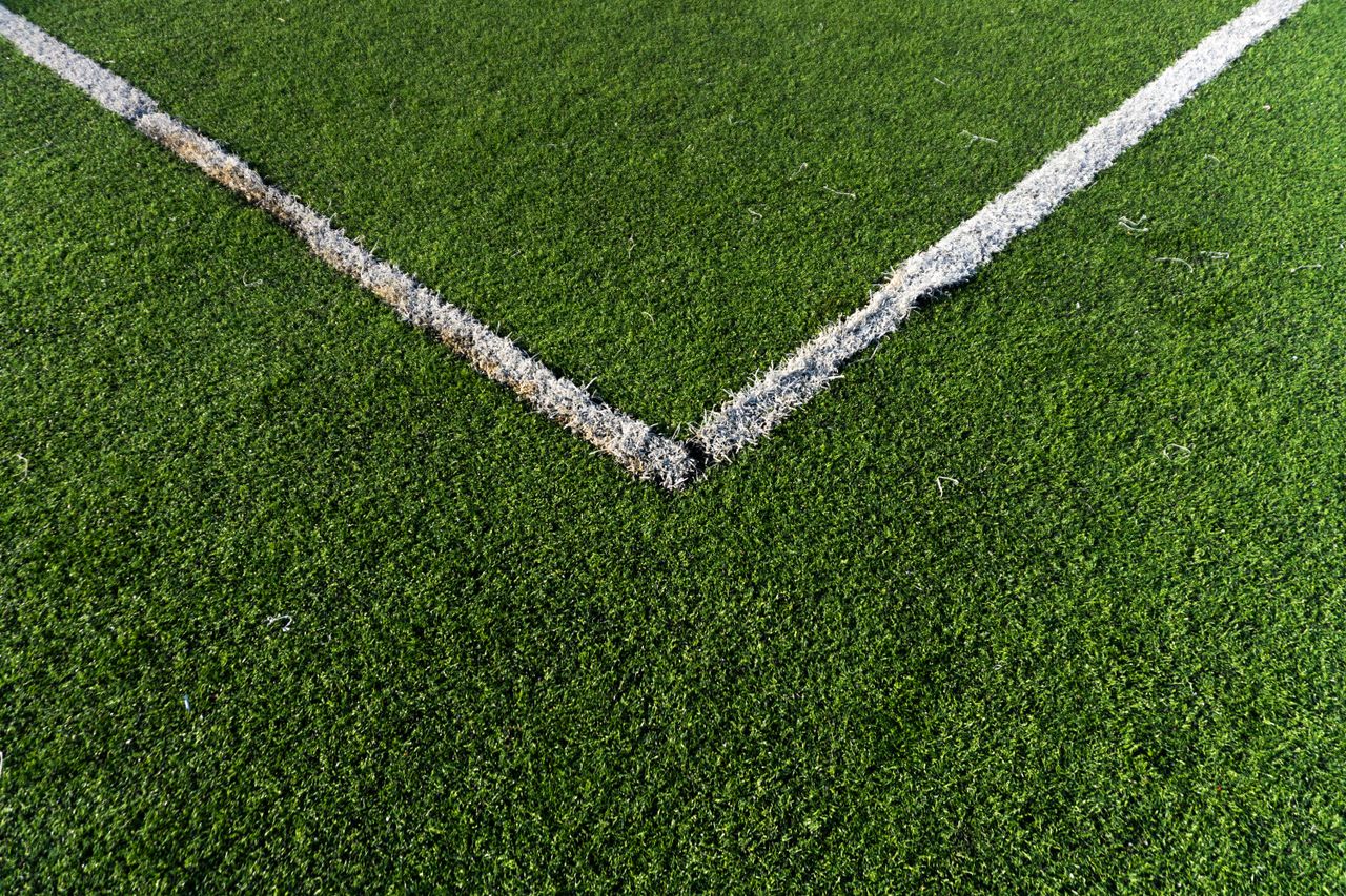 our-story-02 Detailed view of a soccer field corner with vibrant green artificial turf in Istanbul.