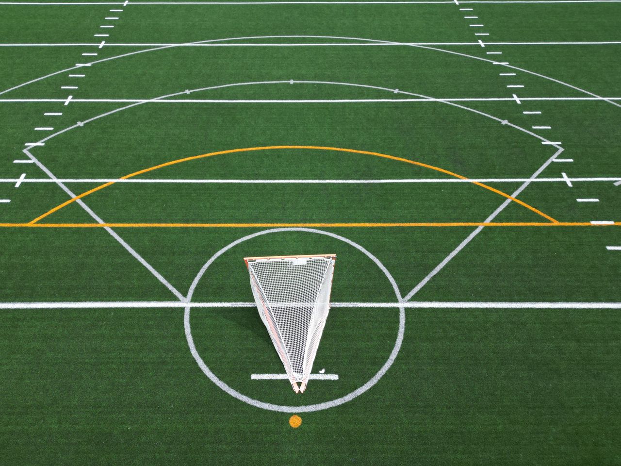 Aerial view of an empty sports field with soccer net and lines.